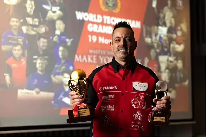 リアム コフィ選手がトロフィーを両手に持ち微笑んでいる写真