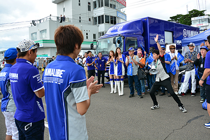 「レース中はヘルメットをかぶっているので、選手の顔ってよく分からなかったけれど、集合写真撮影時に間近で顔を見たらものすごくカッコよくて！　一気にレースファンになってしまいました」とレース好きなご主人に連れられてYSP応援団に参加された女性