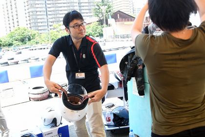 「こうやってあごひも持って少し開くとかぶりやすいですよぉ〜」とアドバイス。バイクのことなら、ワタクシ伊藤にお任せあれ！（ちっちゃくドヤ顔......鼻の穴平常時比約1.5倍）