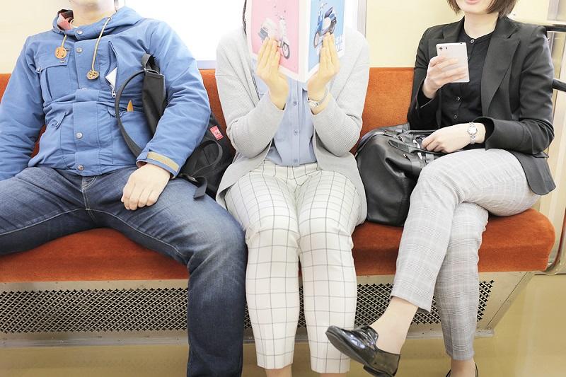 電車内で原付ビーノのカタログをみる女性