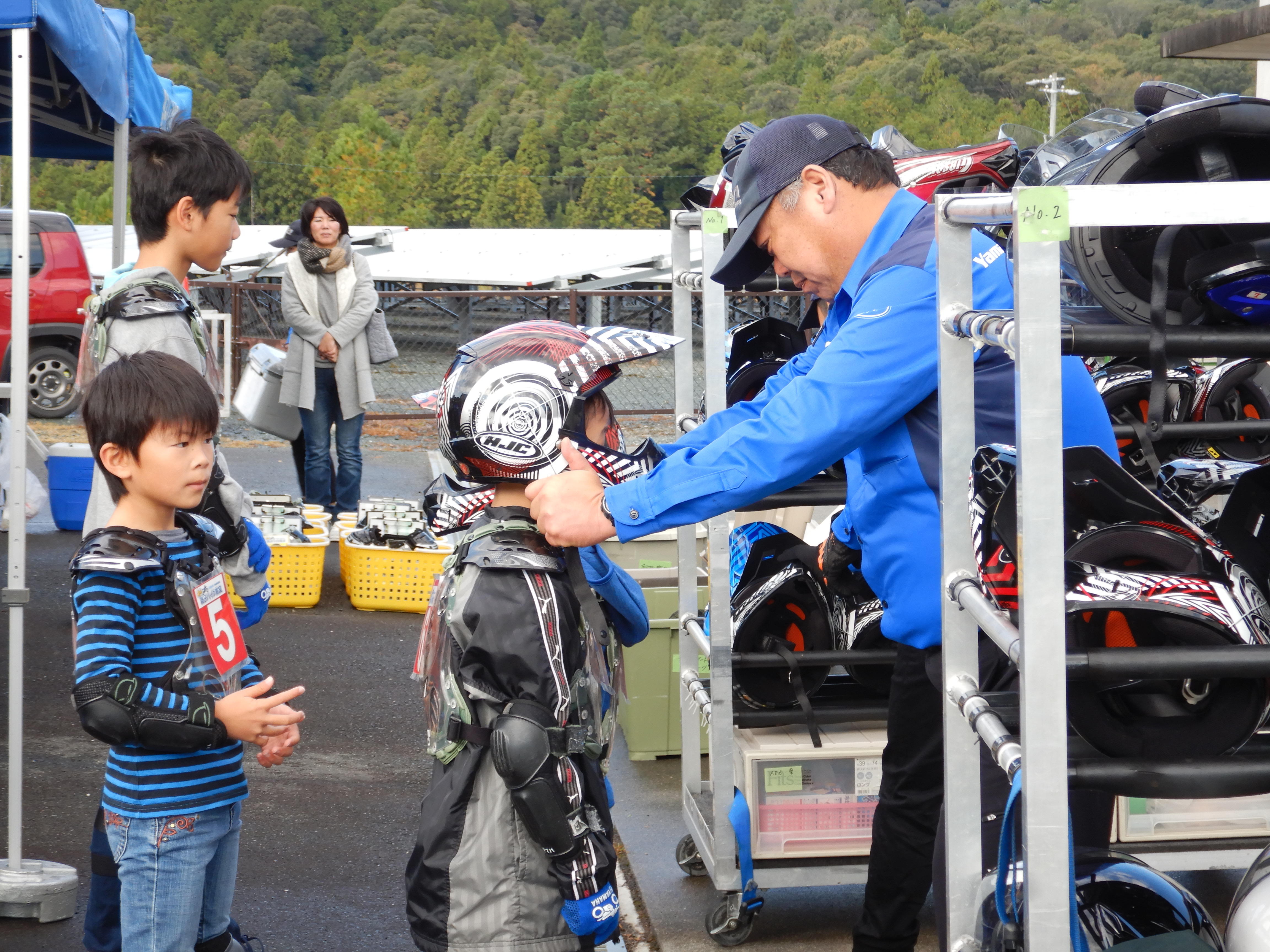 インストラクターの先生に、オフロード専用のヘルメットをかぶせてもらい子供はご機嫌に♪