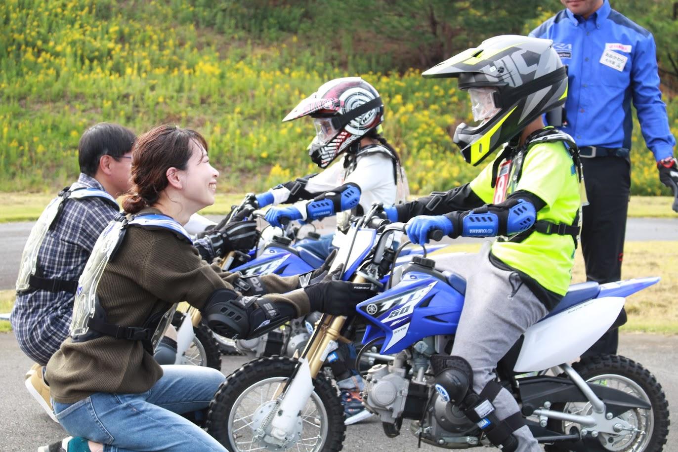 バイクに乗る我が子を見守るお父さん、お母さん