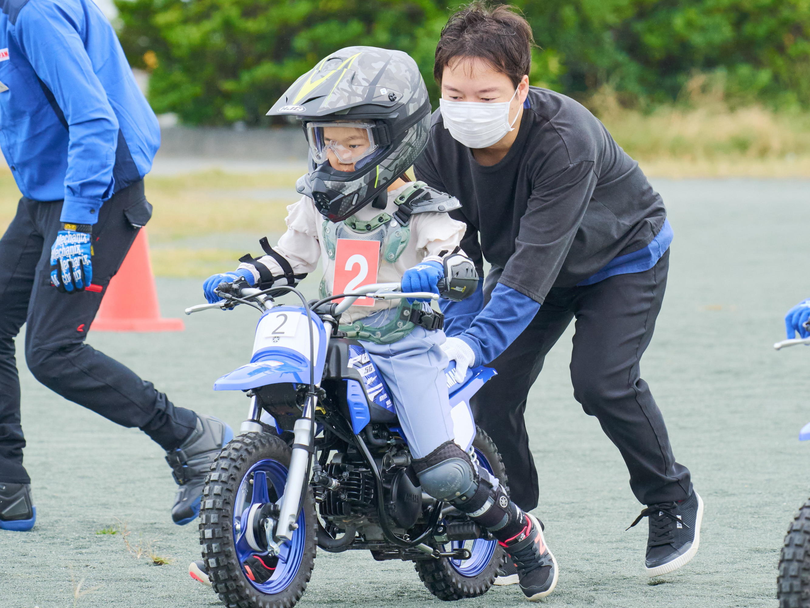 お父さんにバイクを支えてもらう子