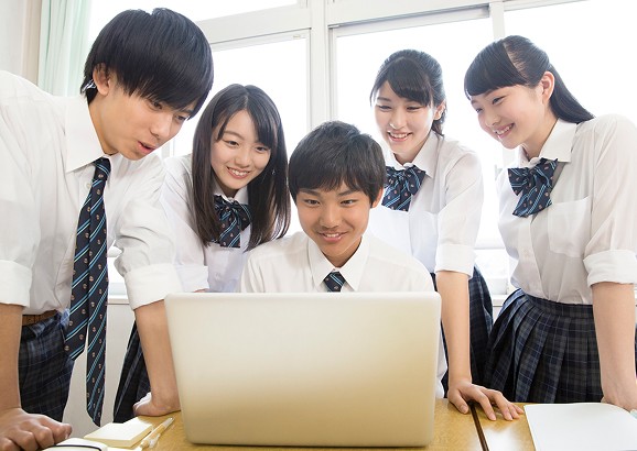 楽しそうにパソコンを見る学生達の写真
